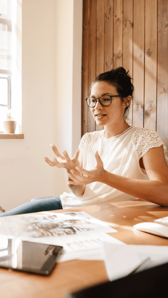 woman discussing a point while cupping her hands deep in thought in a well-lit room